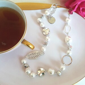 Een moderne twist op de klassieke parelketting met Swarovski parels en skeletblad feature stuk.