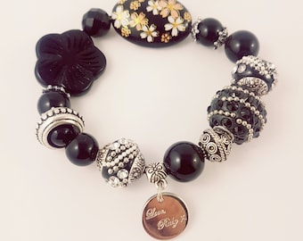 Black and silver bracelet featuring onyx, kashmiri beads and pressed glass.