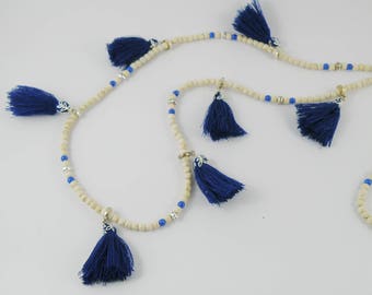 Long boho-inspired necklace of white howlite gemstone with blue glass druk beads and blue cotton tassels.