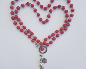 Long beaded necklace of vibrant red riverstone with an affirmation ring and tassel.