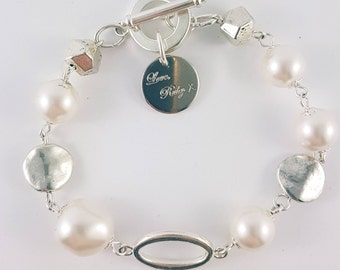 Swarovski pearl bracelet with oval link and silver disc beads.