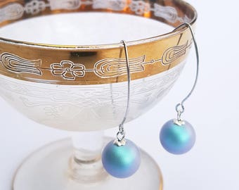 Iridescent light blue Swarovski pearl earrings on long sterling silver hooks.