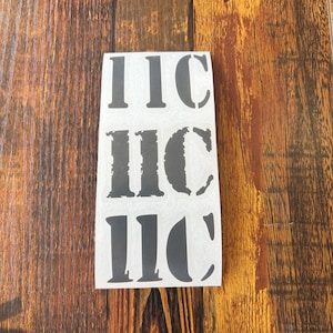 May include: A sheet of three black stencil stickers with the letters IIC. The top sticker has a clean, bold font, the middle sticker has a distressed font, and the bottom sticker has a rounded font.