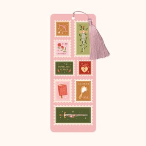 May include: A pink bookmark with a tassel. It features postage stamp designs with illustrations of a bow and arrow, a rose, a sword, a heart, a book, and a mirror. Text includes "ROMANTASY READER" and "CHOSEN ONE".