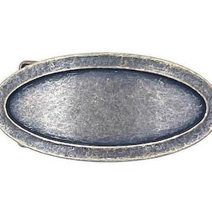 May include: An oval-shaped, antique silver-toned metal buckle with a smooth, slightly textured surface.