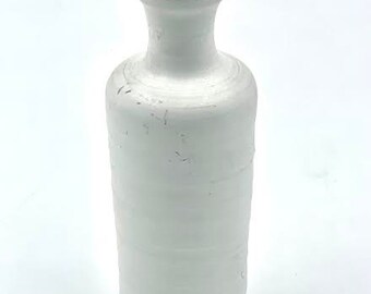 May include: A white ceramic vase with a rounded body and a narrow neck. The vase has a textured, slightly distressed finish.