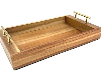 May include: A rectangular wooden serving tray with gold metal handles. The tray is made of light brown wood with a natural grain pattern.