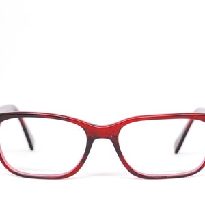 May include: Red plastic framed eyeglasses with clear lenses.
