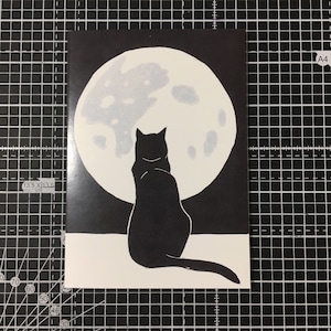 Black cat gazing at the moon greetings card