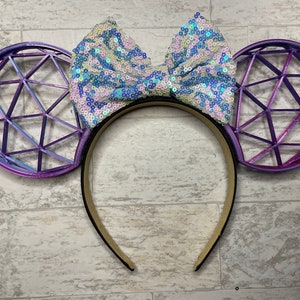May include: Purple and blue geometric patterned headband with a large iridescent sequin bow.