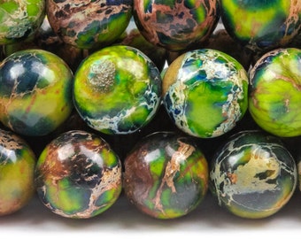 Puede incluir: Primer plano de un hilo de cuentas redondas de piedras preciosas. Las cuentas son una mezcla de verde, marrón y azul, con un patrón veteado. Las cuentas probablemente se utilizan para la fabricación de joyas.