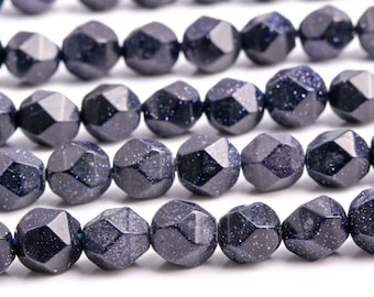 Pode incluir: Um fio de contas de pedra preciosa facetadas azul escuro. As contas têm uma textura salpicada e brilhante.