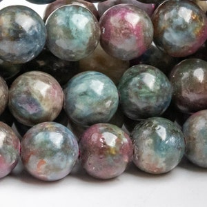 May include: Close-up of a strand of round gemstone beads. The beads are a mix of colors, including shades of green, pink, and gray. The beads have a polished, glossy finish and are strung together.