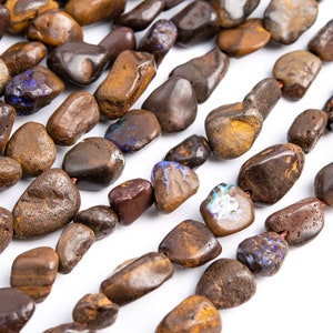 Peut inclure: Un brin de perles de pierres précieuses opales brunes, noires et jaunes. Les perles sont de forme irrégulière et ont une finition lisse et polie.