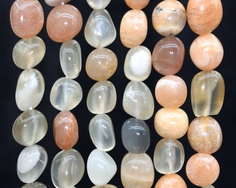 May include: A strand of smooth, oval-shaped sunstone beads in shades of peach, white, and light orange. The beads have a translucent quality and show a shimmery effect.
