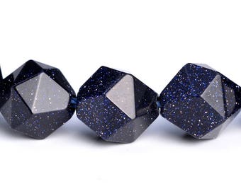 Pode incluir: Um fio de contas de pedras preciosas azul-escuras com uma forma geométrica facetada. As contas têm uma textura salpicada e brilhante.