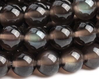 May include: Close-up of a strand of smoky quartz beads. The beads are round, polished, and a translucent smoky brown color. The beads reflect light, creating highlights and shadows. The beads are strung together, ready for jewelry making.