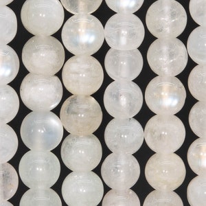 May include: A strand of white moonstone beads. The beads are round and smooth, with a slight iridescent sheen.