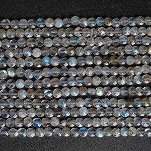 May include: A strand of round, faceted labradorite beads in shades of gray and blue. The beads have a shimmery, iridescent quality.