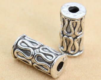 Peut inclure: Deux perles en métal argenté avec un design complexe. Les perles sont cylindriques et ont un trou au centre. Elles sont parfaites pour la fabrication de bijoux ou d'autres projets d'artisanat.