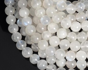 May include: A strand of white moonstone beads. The beads are round and smooth, with a subtle iridescent sheen.