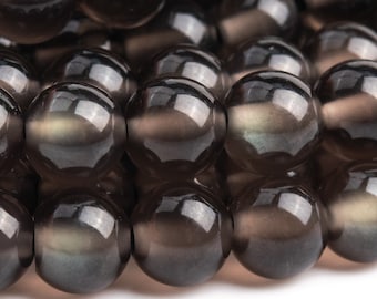 May include: A strand of dark gray gemstone beads with a subtle iridescent sheen. The beads are round and smooth, and they are arranged in a close-up view.