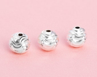 May include: Three silver beads with a wavy, textured design. The beads are round and have a hole in the center.