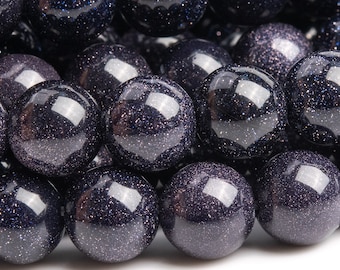 Op de afbeelding: Een close-up van een streng donkerblauwe edelsteen kralen. De kralen zijn rond en hebben een glinsterende, glimmende afwerking.
