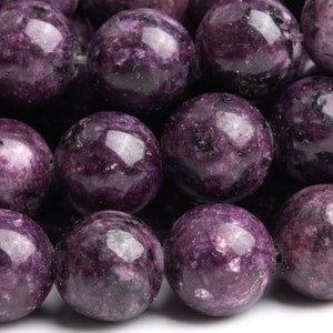 May include: A strand of purple and black gemstone beads. The beads are round and have a smooth, polished finish.
