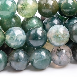 May include: A strand of green agate beads with a mottled pattern. The beads are round and smooth, and they have a natural, earthy look.