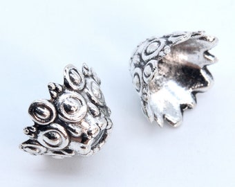 Op de afbeelding: Twee zilveren metalen kralencaps met een decoratief ontwerp. De doppen hebben een afgeronde bovenkant en een gegolfde rand.