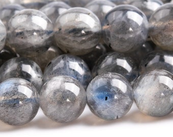 May include: A strand of round, grey labradorite beads with iridescent blue flashes. The beads are smooth and polished.