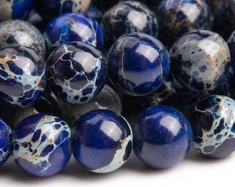 Puede incluir: Una hebra de cuentas de piedra preciosa marmoleadas azules y blancas. Las cuentas son redondas y tienen un acabado liso y pulido.