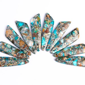 May include: A collection of ten turquoise, brown, and silver iridescent gemstone pendants arranged in a semi-circle.