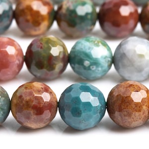 May include: A strand of faceted gemstone beads in shades of green, brown, and pink. The beads are round and have a polished finish.