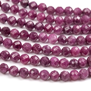 Op de afbeelding: Een streng facetgeslepen roze robijn kralen. De kralen zijn rond en hebben een gladde, gepolijste afwerking.