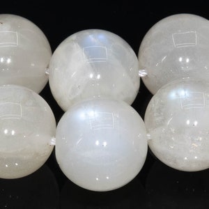 May include: A strand of white moonstone beads. The beads are round and smooth, with a slight iridescent sheen.