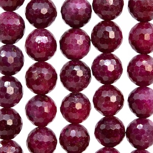 Op de afbeelding: Een streng facetgeslepen robijn kralen. De kralen zijn diep rood van kleur en hebben een gepolijste, glanzende afwerking.