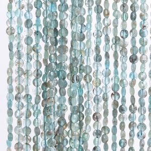 May include: A strand of light blue aquamarine gemstone beads. The beads are oval shaped and have a smooth, polished finish.