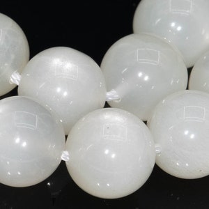 May include: A strand of white moonstone beads. The beads are round and smooth, with a subtle shimmer.