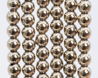 May include: Close-up of a collection of shiny, metallic spheres arranged in neat rows. The spheres have a reflective surface, creating highlights and shadows. The arrangement suggests a pattern or structure, possibly for decorative or functional purposes.