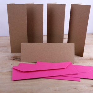 May include: Five brown cardstock envelopes and a stack of six bright pink envelopes.