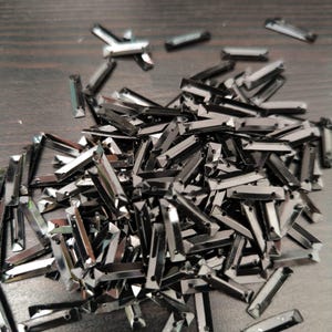 May include: A white ceramic mug with a black handle and the text "But First, Coffee" in a bold, black font. The mug is on a wooden surface. The mug is approximately 10 cm tall.