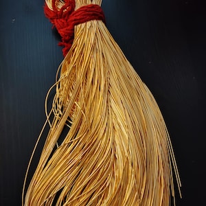 Puede incluir: Un haz de alambre de color dorado atado con una cuerda roja.
