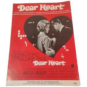 May include: A vintage sheet music cover for "Dear Heart" in red, featuring a heart-shaped image of a man and woman. The title and credits are in white and black, with the names Glenn Ford and Geraldine Page prominently displayed.