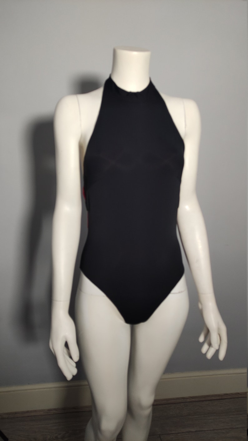 May include: A black halter-style swimsuit with a high neckline.