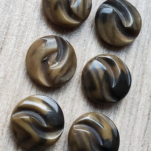 May include: Six brown and black swirl patterned buttons. The buttons are round and have a raised design.