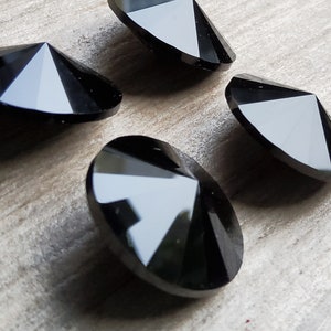 Peut inclure: Quatre formes de diamant facettées en cristal noir. Les cristaux sont réfléchissants et ont une pointe pointue.