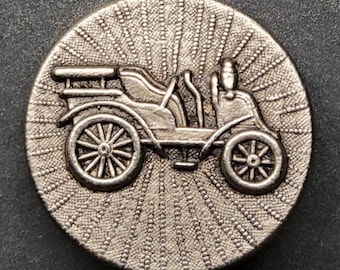 Vintage large metal button of a vintage automobile.