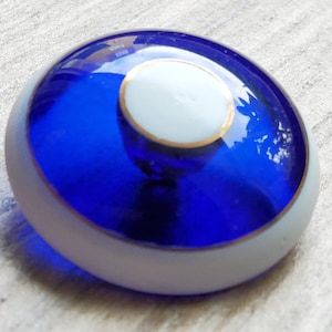 Bottone vintage di grandi dimensioni in vetro blu trasparente e smalto bianco, risalente ai primi anni del 1900.